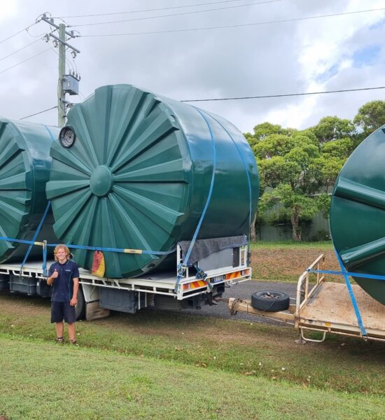 Maroochydore plumber standing in front of large water tanks