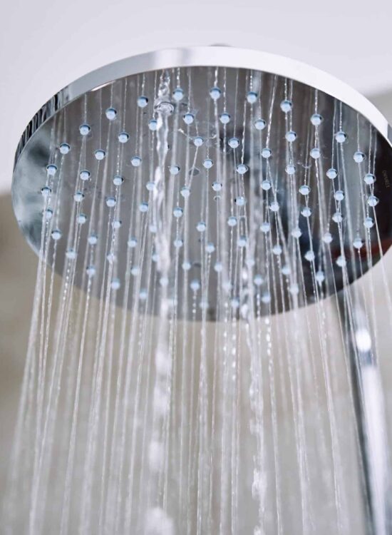 hot water systems Sunshine Coast - Water Flowing From Shower Head In Bathroom