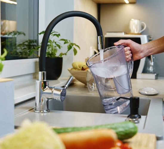 Woman Pouring Water Filter Jug after a kitchen renovation in Sunshine Coast